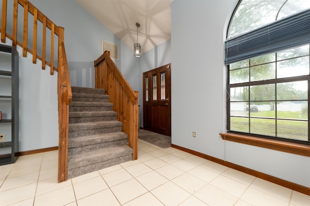 entrance foyer featuring light tile patterned floors and lofted ceiling