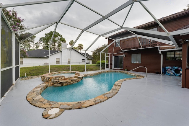 view of swimming pool featuring glass enclosure, an in ground hot tub, and a patio