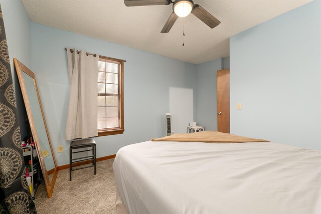 carpeted bedroom featuring a textured ceiling and ceiling fan