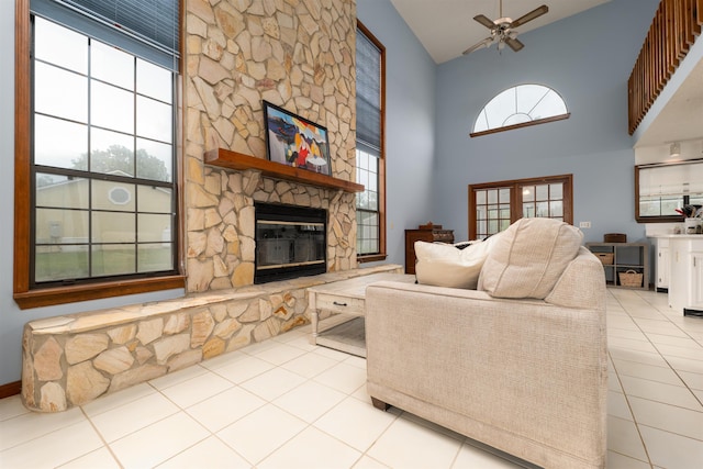 tiled living room with a fireplace, high vaulted ceiling, and ceiling fan