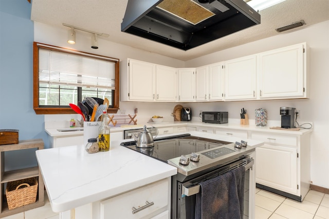 kitchen featuring a center island, light tile patterned floors, range hood, range with electric stovetop, and white cabinets