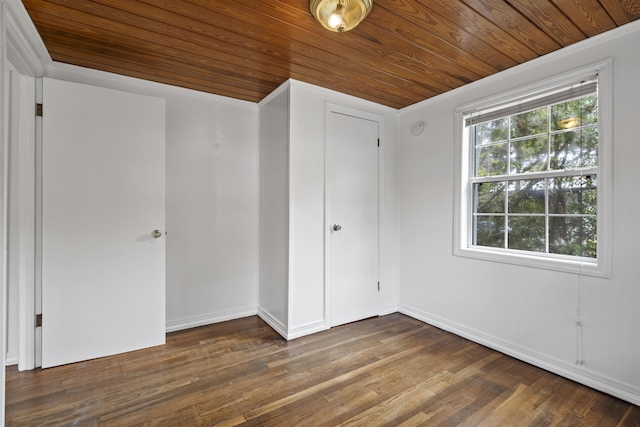 unfurnished bedroom with a closet, dark wood-type flooring, and wood ceiling