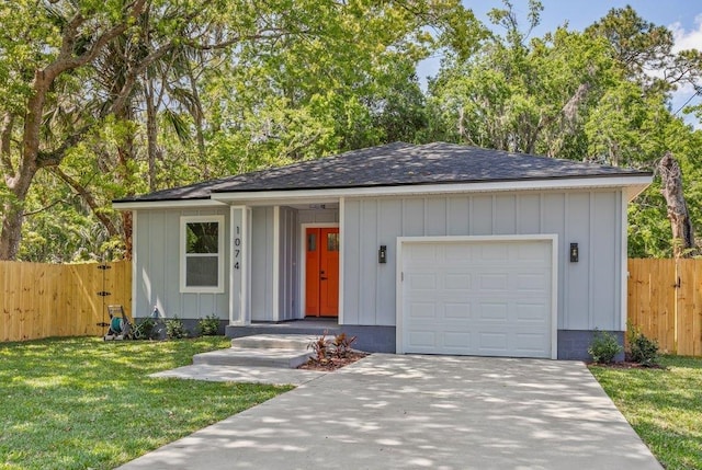 ranch-style home featuring board and batten siding, a garage, a front yard, fence, and driveway