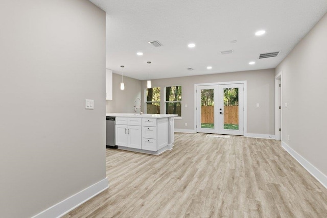 kitchen with stainless steel dishwasher, baseboards, white cabinetry, and visible vents