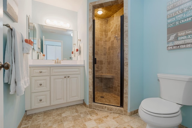 full bath with vanity, a shower stall, toilet, and baseboards