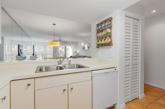 kitchen with light countertops, dishwasher, a sink, and light tile patterned floors