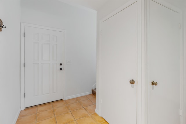 corridor featuring light tile patterned flooring and baseboards