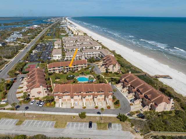 drone / aerial view featuring a residential view, a water view, and a beach view