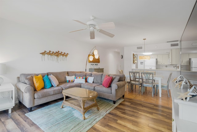 living area with visible vents, a ceiling fan, and light wood-style floors