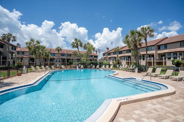 pool featuring a patio area, a residential view, and fence