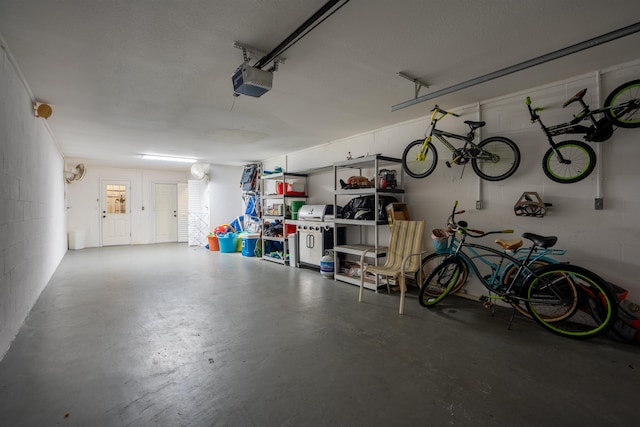 garage with a garage door opener and concrete block wall