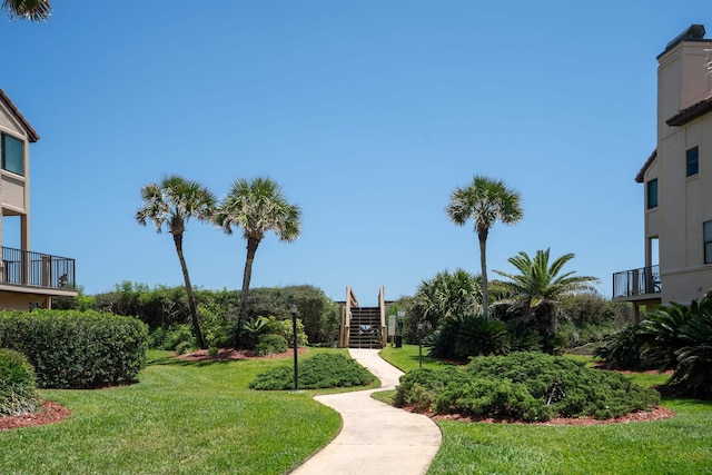 surrounding community with stairway and a yard