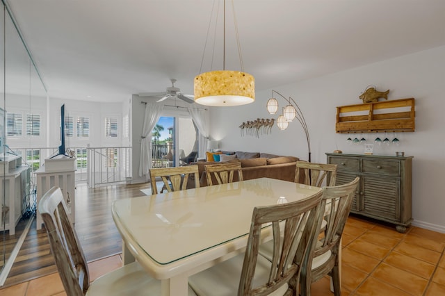 dining space featuring ceiling fan, light tile patterned floors, and baseboards