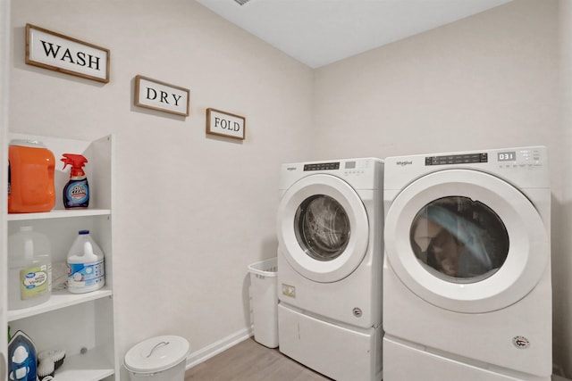 clothes washing area with independent washer and dryer and light hardwood / wood-style flooring