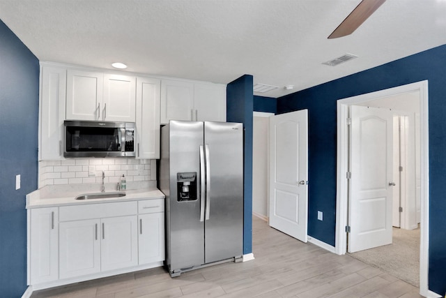 123 Hickory Ridge Rd, Saint Augustine, FL 32084 - kitchen featuring appliances with stainless steel finishes, decorative backsplash, light wood-style flooring, light countertops, and white cabinetry