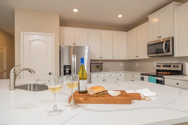 101 Sailors Landing Ct, Saint Augustine, FL 32084 - kitchen with a sink, white cabinetry, light stone counters, and appliances with stainless steel finishes
