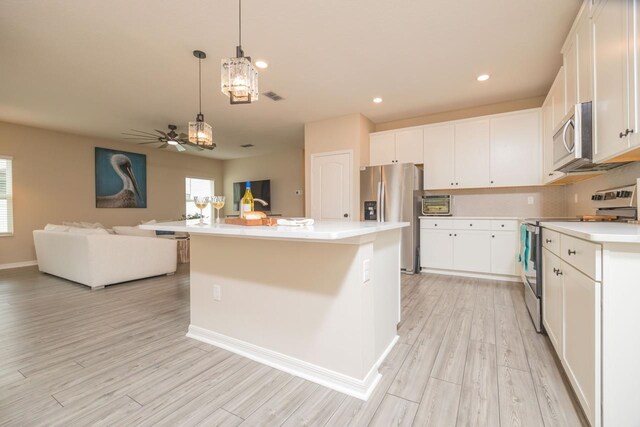 101 Sailors Landing Ct, Saint Augustine, FL 32084 - kitchen featuring light countertops, light wood finished floors, white cabinetry, appliances with stainless steel finishes, and open floor plan