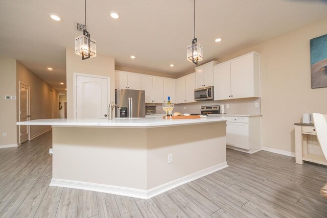 101 Sailors Landing Ct, Saint Augustine, FL 32084 - kitchen featuring light wood finished floors, white cabinetry, light countertops, and appliances with stainless steel finishes