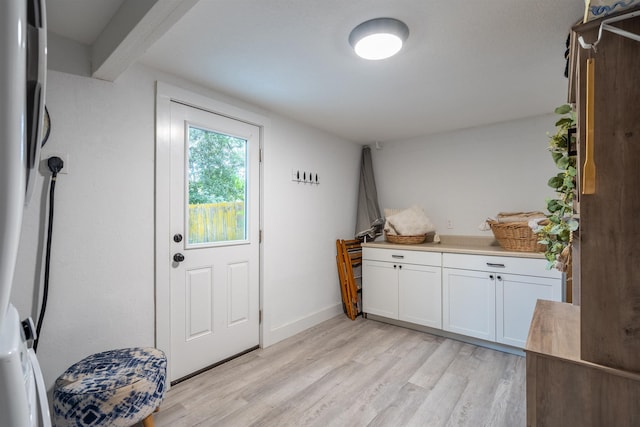 doorway featuring light hardwood / wood-style flooring and beamed ceiling