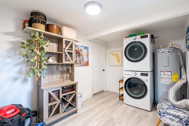 laundry room with stacked washer / drying machine, light wood-type flooring, and water heater