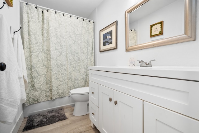 bathroom featuring wood-type flooring, vanity, and toilet