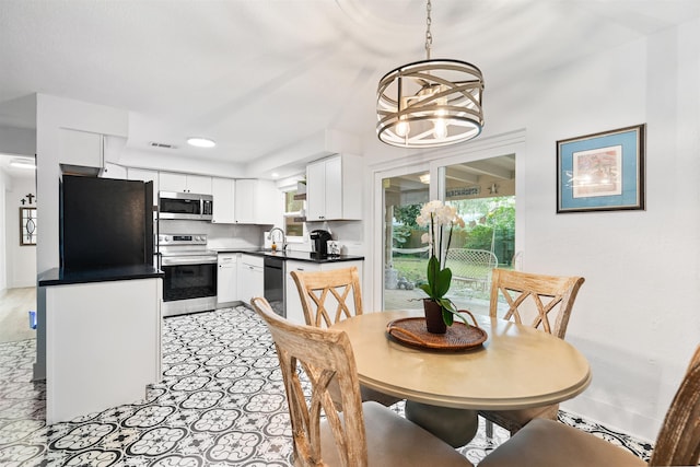 dining space with a notable chandelier, a healthy amount of sunlight, and sink