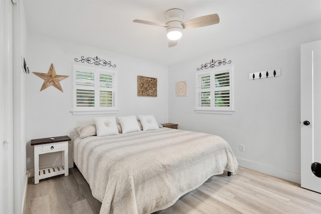 bedroom featuring multiple windows, ceiling fan, and light hardwood / wood-style flooring