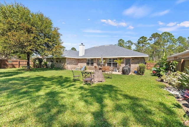 14 Serbian Bellflower Trl, Palm Coast, FL 32164 - rear view of house with a lawn, a chimney, fence private yard, and a patio area