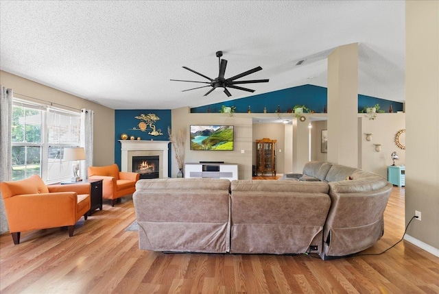 14 Serbian Bellflower Trl, Palm Coast, FL 32164 - living area with a warm lit fireplace, a textured ceiling, light wood-type flooring, and a ceiling fan