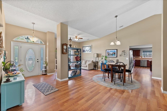 14 Serbian Bellflower Trl, Palm Coast, FL 32164 - entryway with ceiling fan with notable chandelier, light wood-style flooring, baseboards, and a textured ceiling