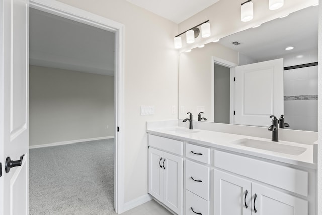 bathroom featuring double vanity, visible vents, baseboards, and a sink