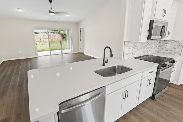 kitchen with a sink, tasteful backsplash, open floor plan, stainless steel appliances, and light countertops