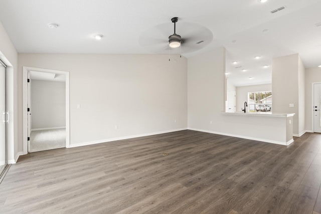 unfurnished living room featuring dark wood finished floors, visible vents, baseboards, and ceiling fan