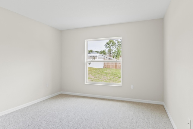 spare room featuring baseboards and carpet