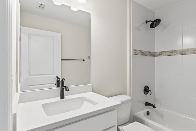 bathroom with vanity, visible vents, shower / bath combination, toilet, and a textured wall