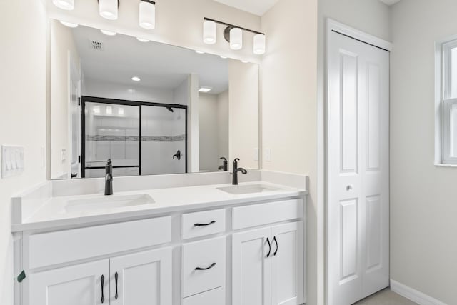 full bathroom with double vanity, visible vents, a stall shower, and a sink