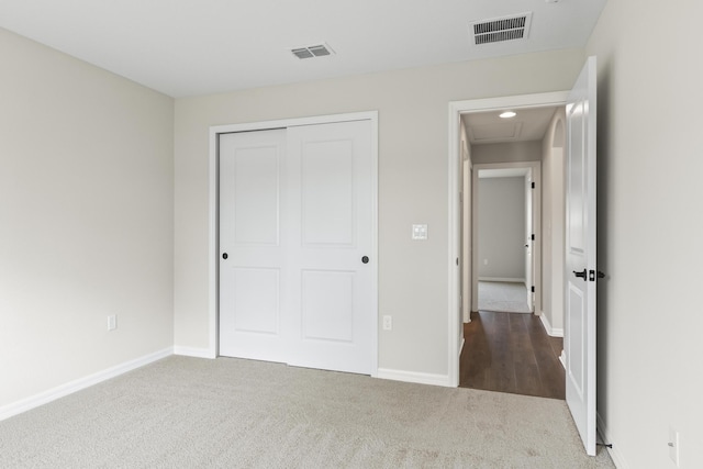 unfurnished bedroom with visible vents, carpet flooring, and baseboards