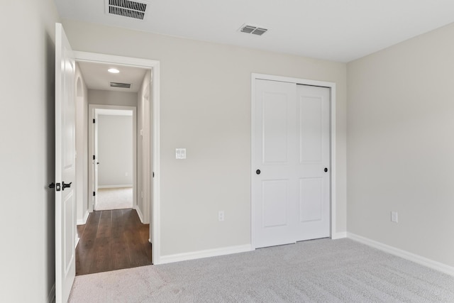 unfurnished bedroom featuring a closet, baseboards, visible vents, and carpet floors