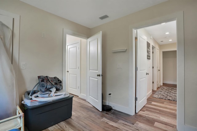 corridor with light hardwood / wood-style floors