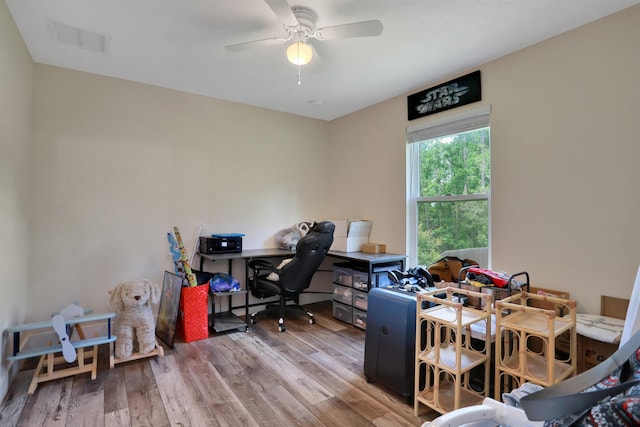 office with light hardwood / wood-style floors and ceiling fan