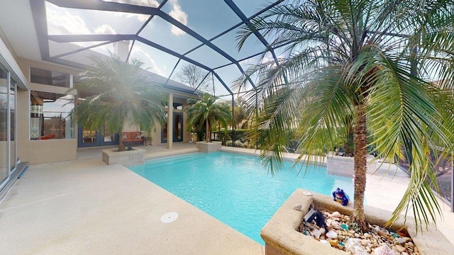 view of swimming pool with a patio area and glass enclosure