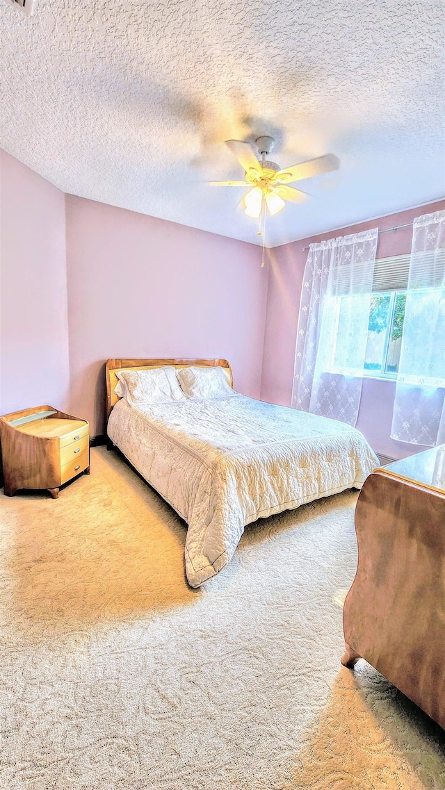 bedroom with carpet flooring, ceiling fan, and a textured ceiling