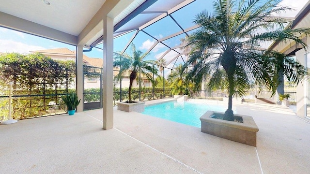 view of pool with a lanai, pool water feature, and a patio area