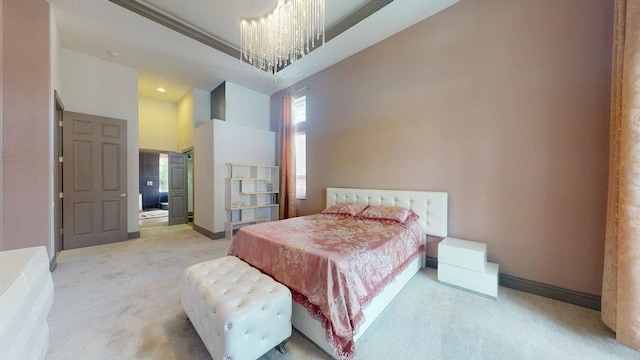 carpeted bedroom with an inviting chandelier and a high ceiling