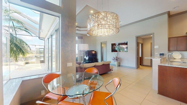 tiled dining area with a high ceiling, crown molding, sink, and an inviting chandelier