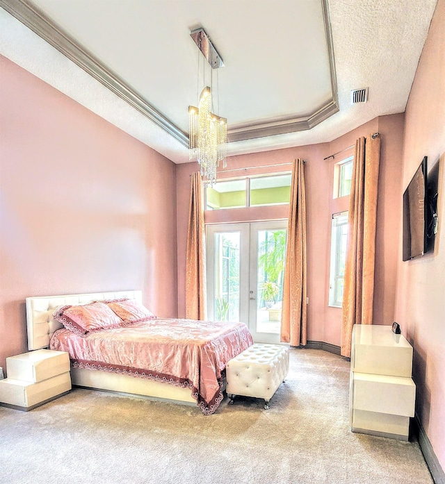 bedroom featuring access to outside, carpet flooring, french doors, and a tray ceiling