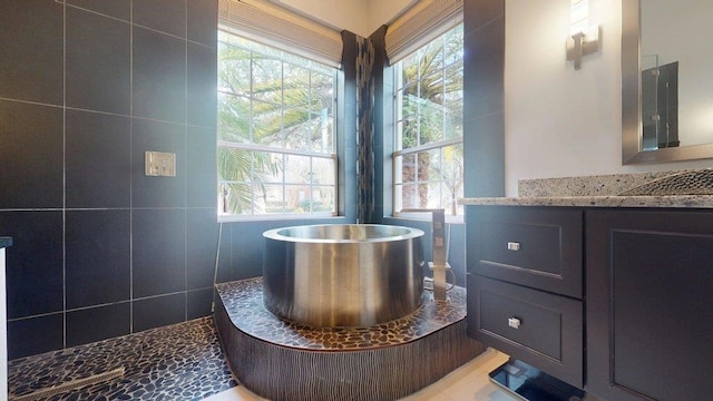 bathroom featuring a tub to relax in and vanity