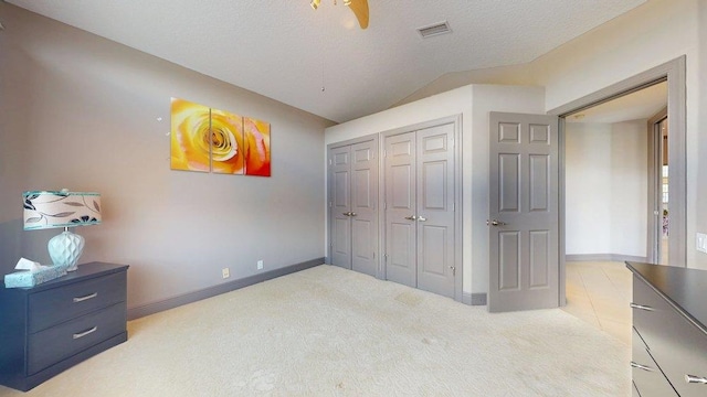 carpeted bedroom with lofted ceiling and a textured ceiling