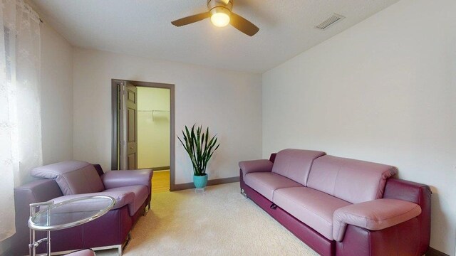 carpeted living room with ceiling fan