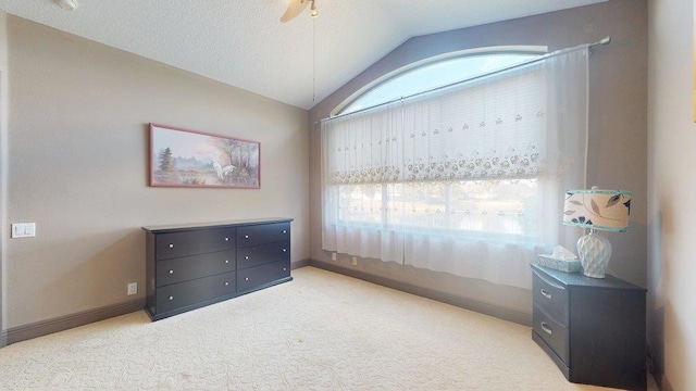 carpeted bedroom with multiple windows, vaulted ceiling, and a textured ceiling